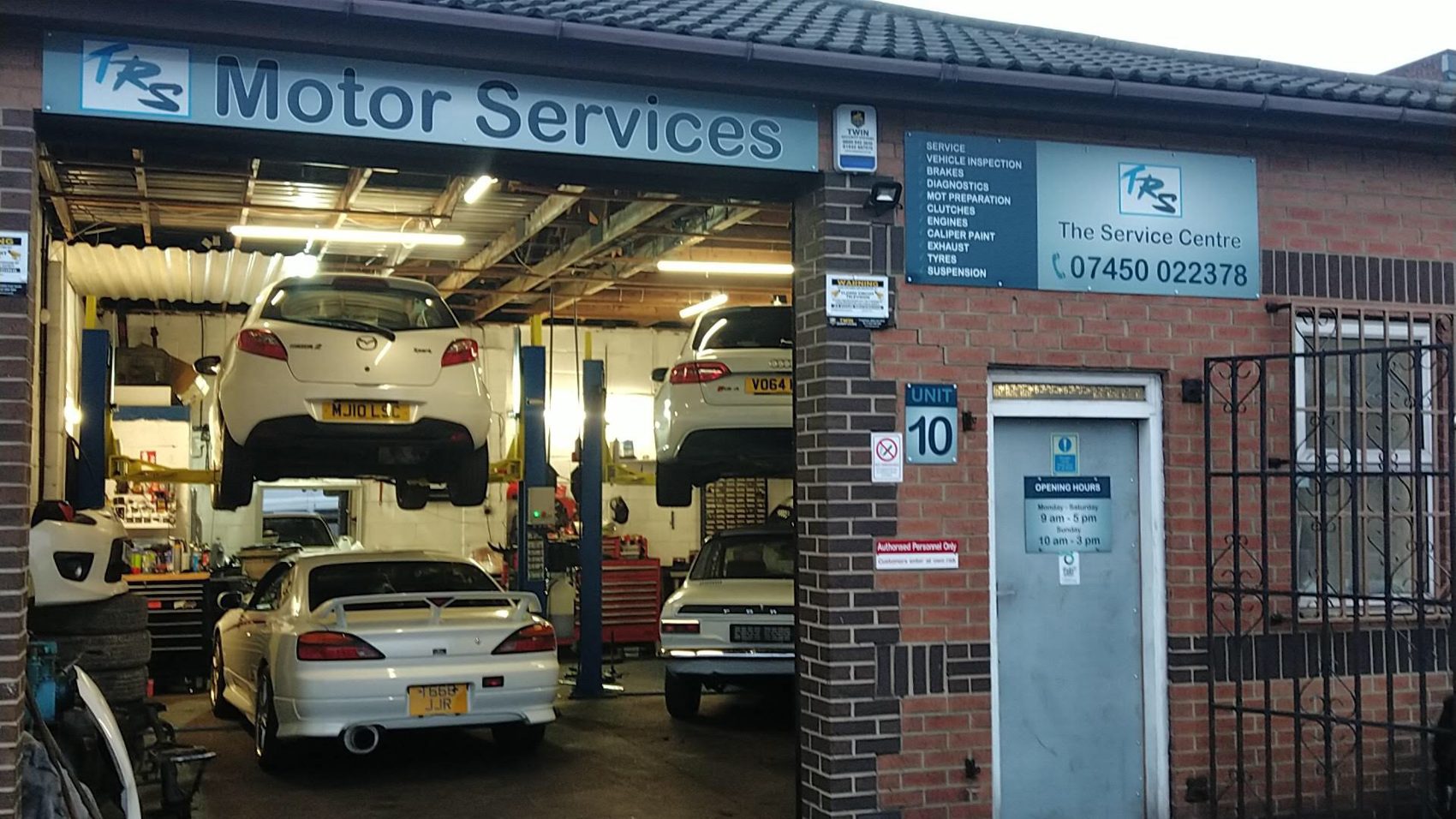 The front of TRS Motor Services: the Motor Services sign above an open bay with a white sports car on the lift